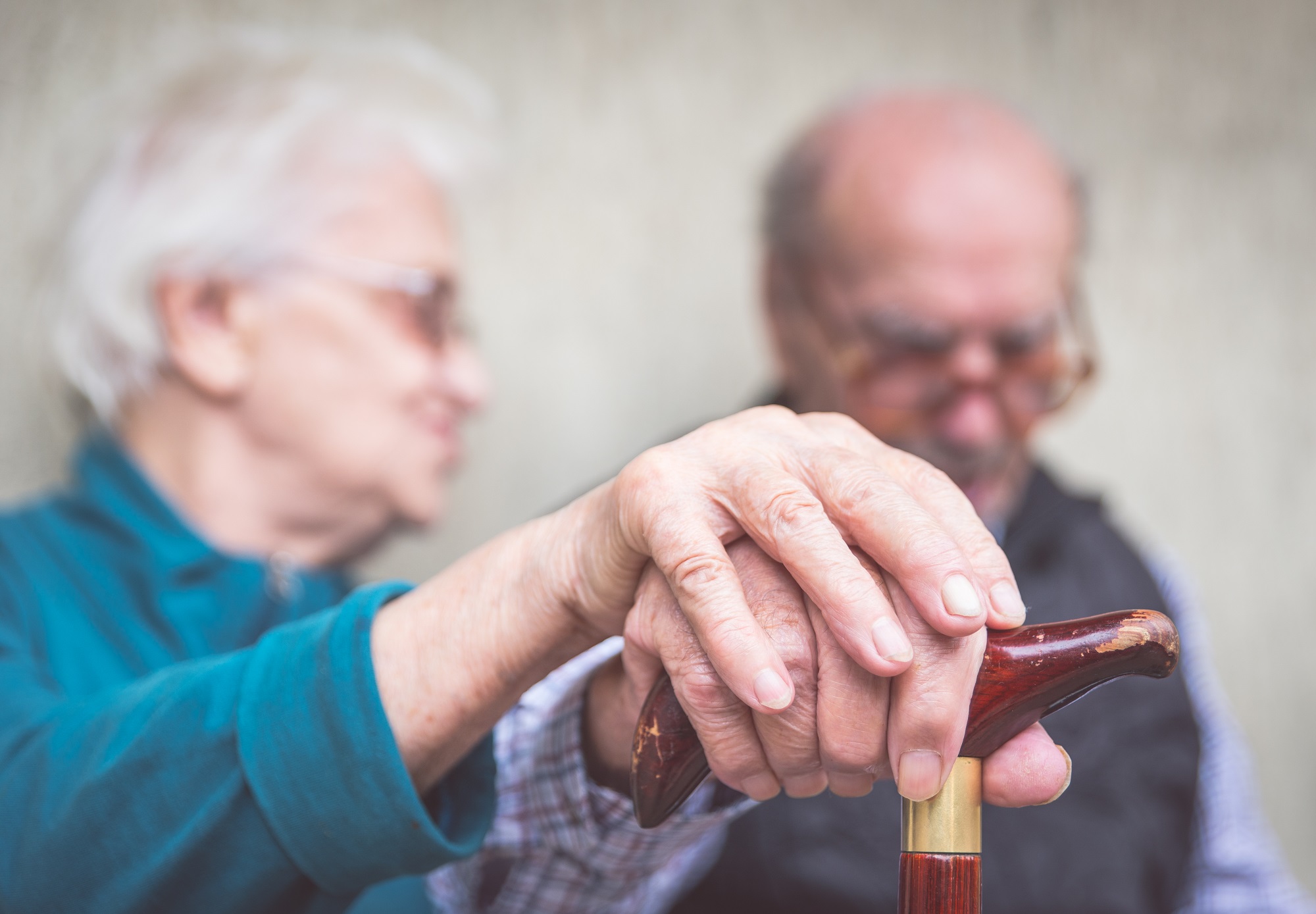 Photo of older couple holding hands and looking downward