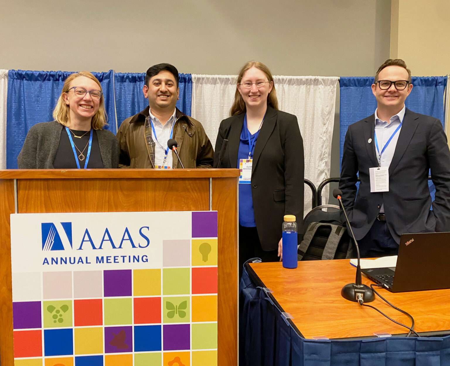 Four panelists standing behind podium