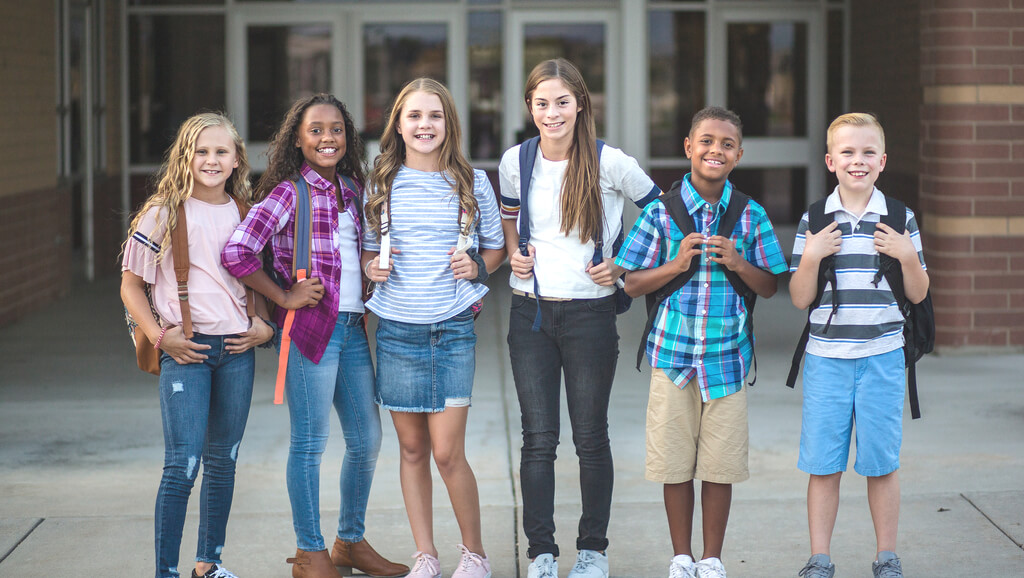 Adolescents posing outside of school
