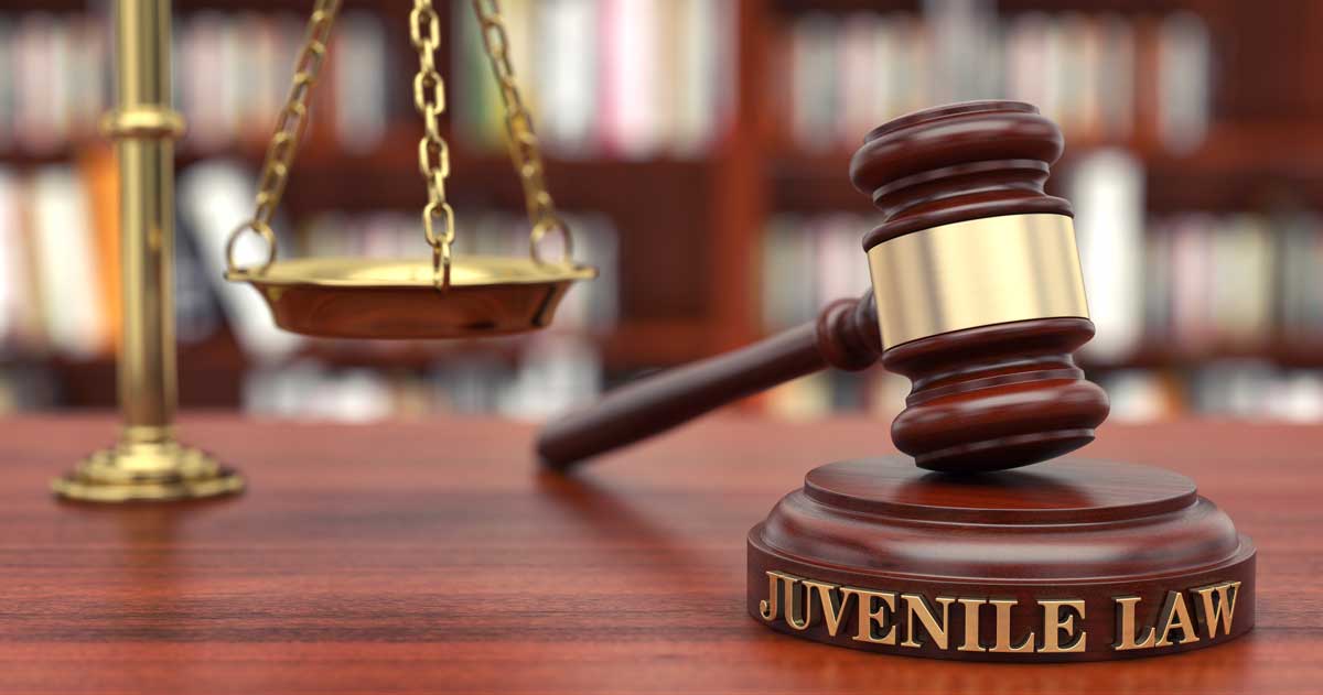 Closeup photo of gavel and scales of justice on a desk with words "Juvenile Law"