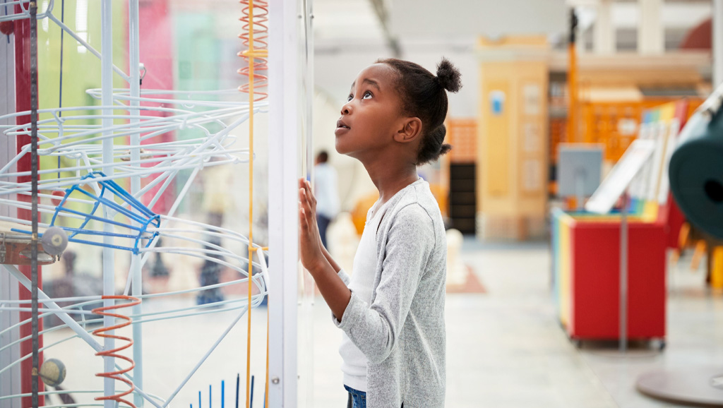 Young girl looking up at science experiment