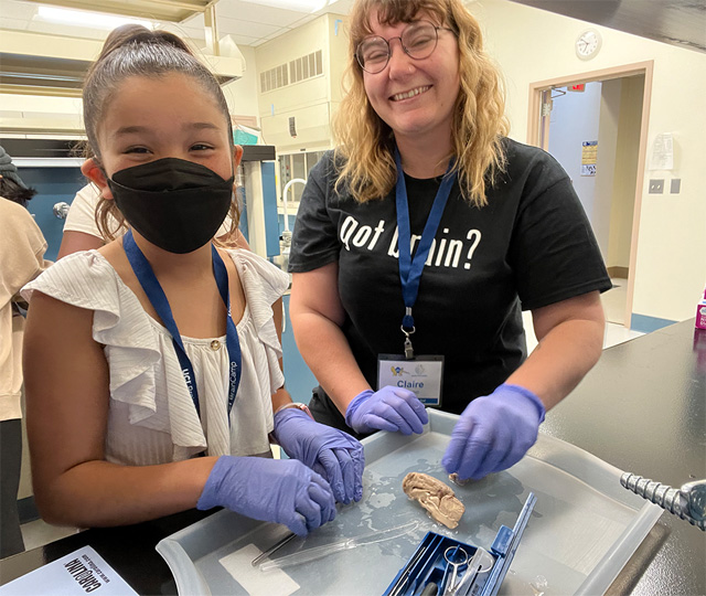 Photo of child and adult in a lab learning about the brain