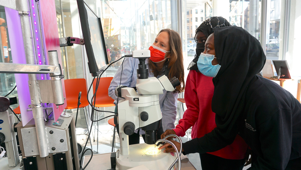 Photo of interview subject in a lab explaining research to students