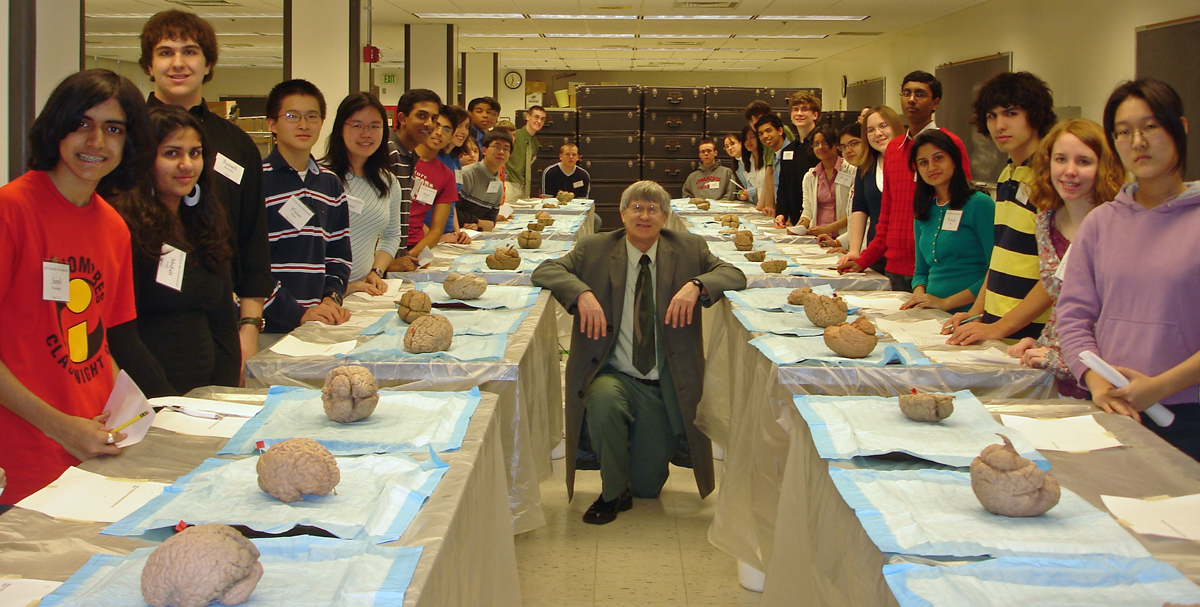 Photo of Mylinski between two rows of Brain Bee participants and brains