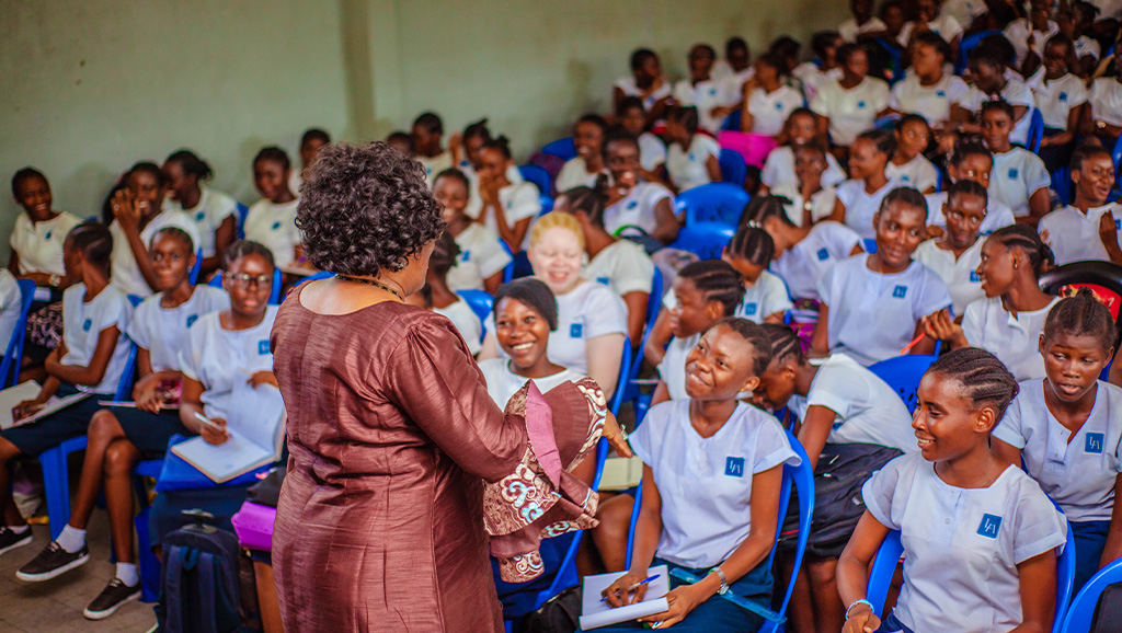 Woman speaking to a happy crowd of young students