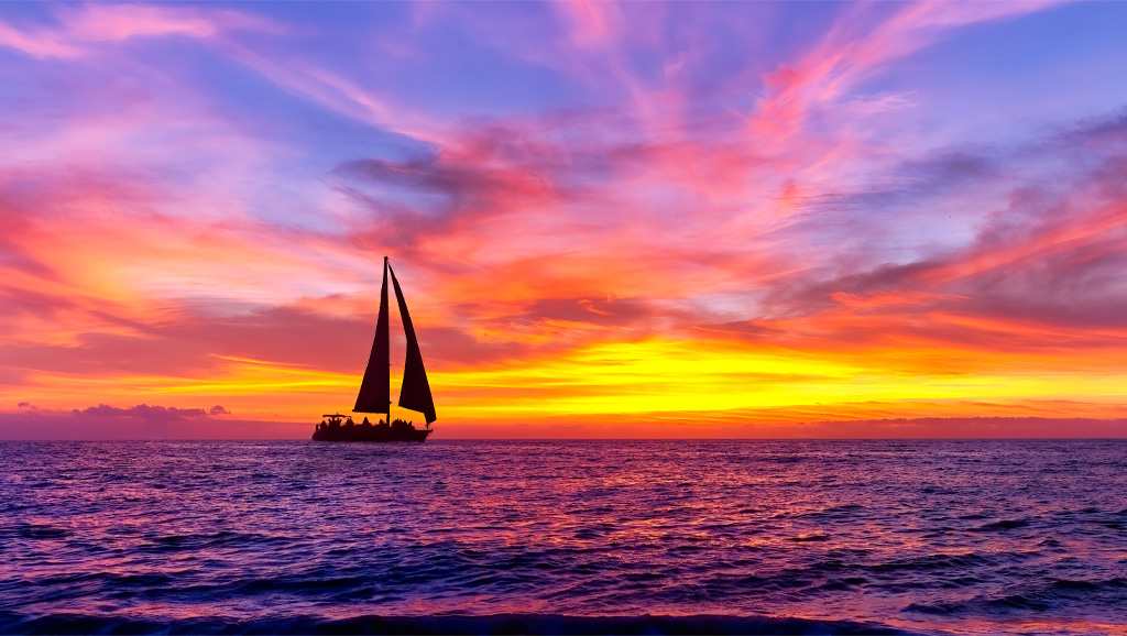 Colorful sunset with silhouette of a sailboat