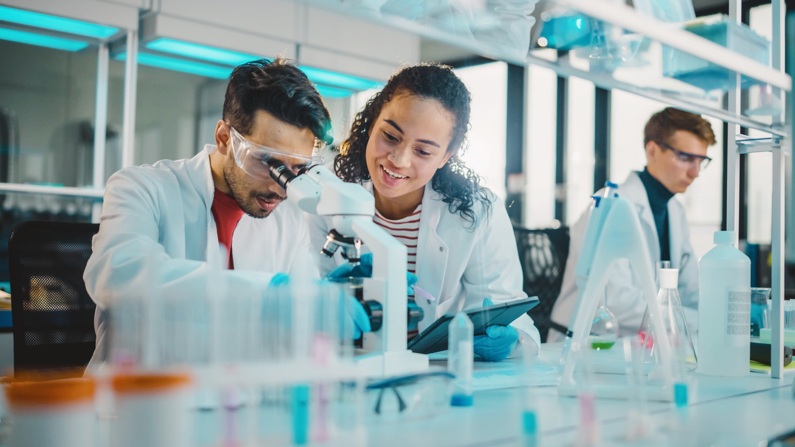 Two students in a laboratory looking into a microscope