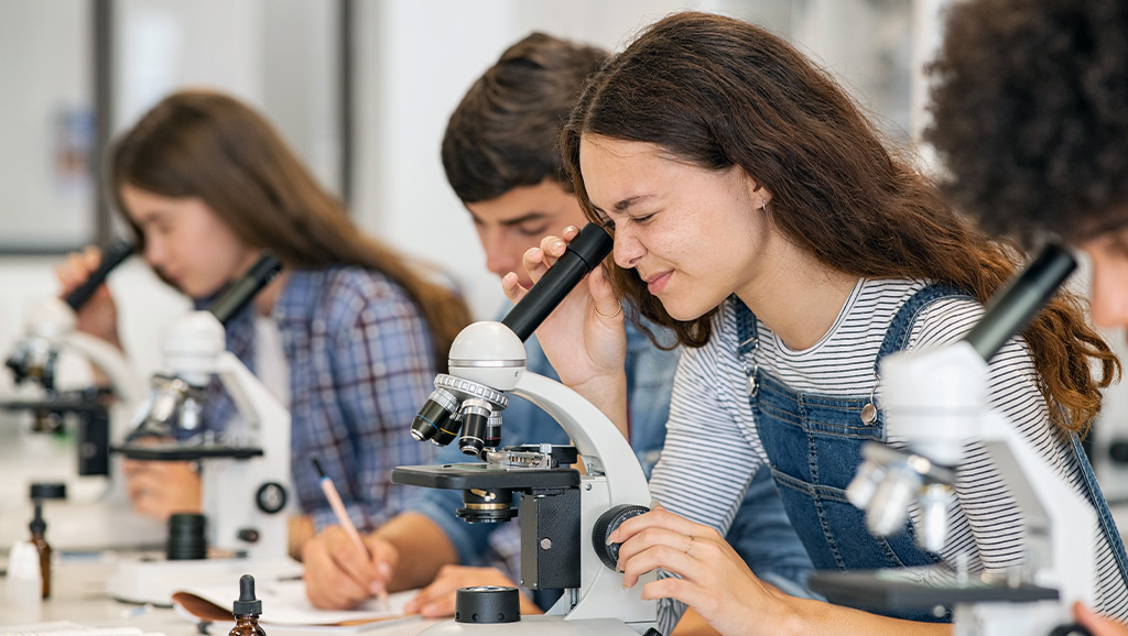 Photo of students looking through microscope